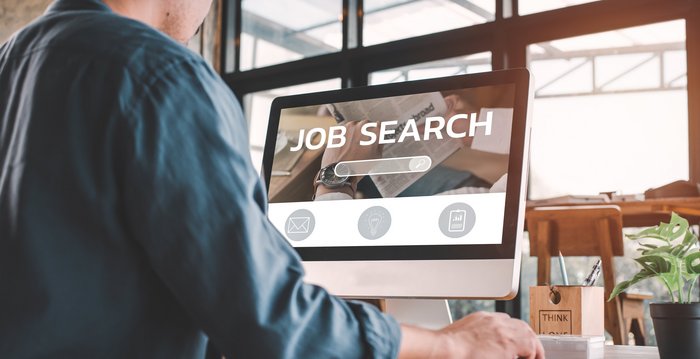 Ein Mann der an einem Pc nach Stellenangeboten sucht